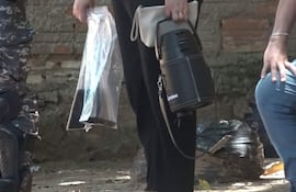 Un agente de la Fiscalía lleva al arma homicida y dos celulares.