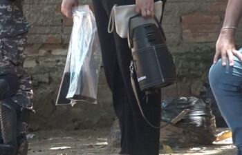 Un agente de la Fiscalía lleva al arma homicida y dos celulares.
