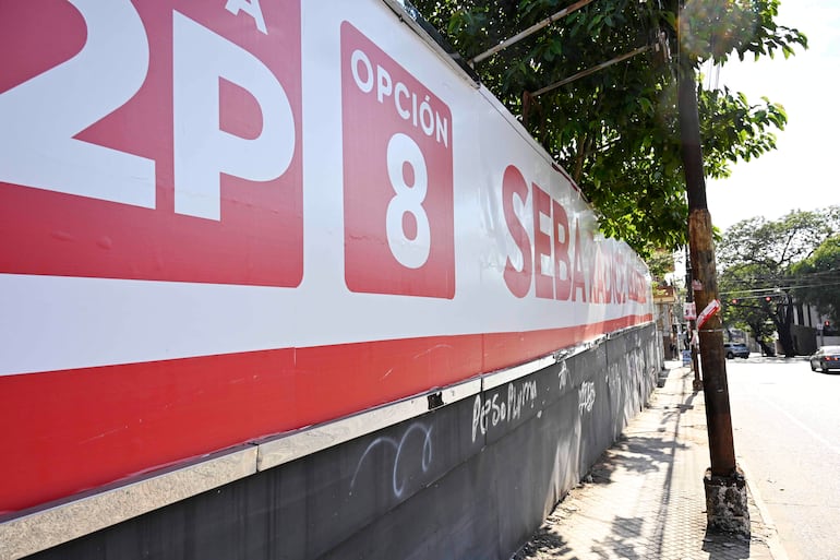 Cartel electoral con el texto 'OPCIÓN 8 SEBA' en una pared de una calle urbana.