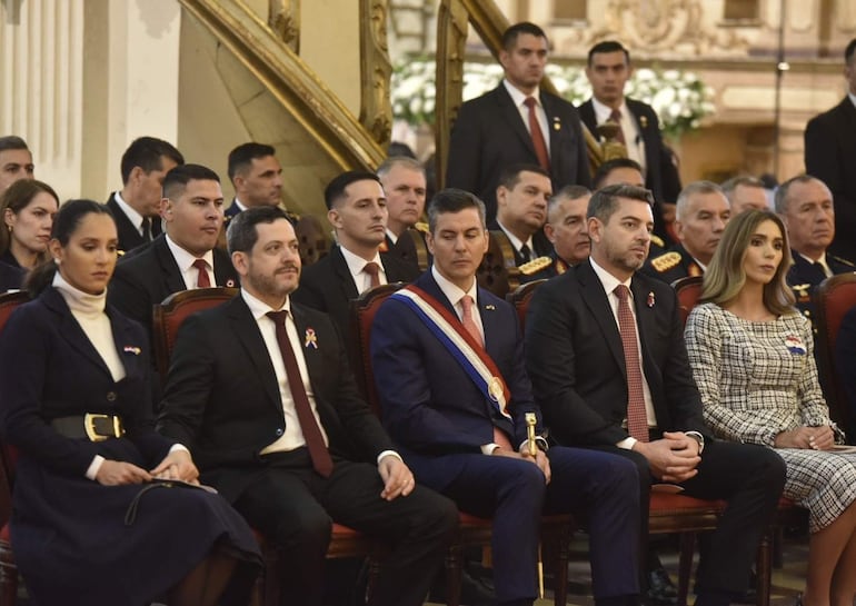 Raúl Luis Latorre Martínez, en el centro con banda presidencial, rodeado de hombres y una mujer elegante, todos atentos en ceremonia formal.