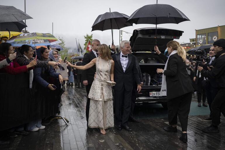 Así, juntitos y muy elegantes bajo una llovizna, llegaron Richard Gere y su bella esposa a la proyección de 'Wisdom of Happiness' en el Zurich Film Festival (ZFF). (EFE/EPA/ENNIO LEANZA)