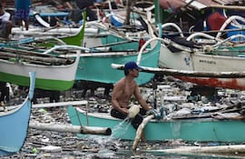 Un pescador asegura una embarcación en la ciudad de Navotas, Metro Manila, Filipinas, el 25 de julio de 2025. El Consejo Nacional para la Reducción y Gestión del Riesgo de Desastres de Filipinas (NDRRMC, por sus siglas en inglés) informó ese día que el número de muertos por los efectos combinados de más de una semana de tormentas ascendía a 25, y que más de un millón de familias se vieron afectadas mientras la tormenta tropical Co-May azotaba la parte norte de la isla principal de Luzón.