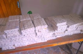Cajas apiladas sobre una mesa de madera, todas envueltas cuidadosamente, en un ambiente cerrado sin personas presentes.