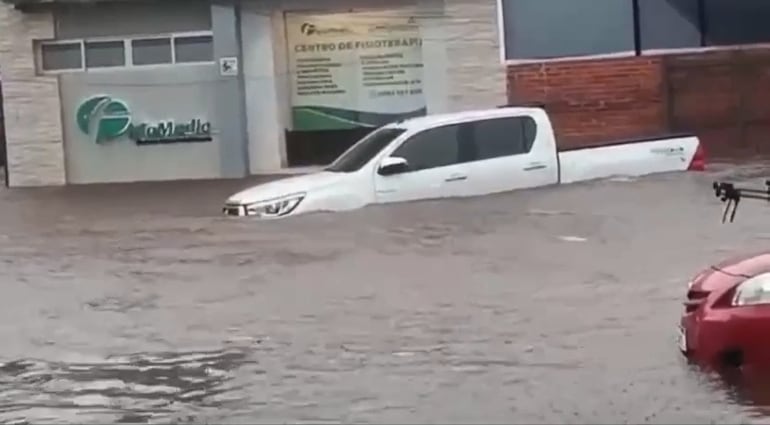 Camioneta arrastrada por el raudal frente al Sanatorio Metropolitano, en Fernando de la Mora.