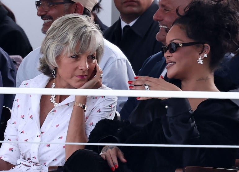La pianista franco-canadiense Hélène Mercier-Arnault (izq.) conversa con la cantante barbadense Rihanna antes del desfile de la colección femenina Primavera/Verano 2027 de Christian Dior, en el marco de la Semana de la Moda de París. (SIMON WOHLFAHRT / AFP)