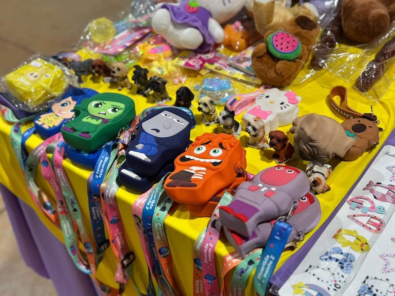 Mesa con coloridos estuches y juguetes en el Abasto Este, sin personas visibles.