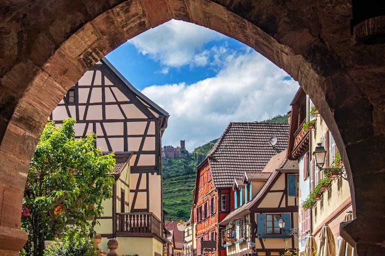 Casas de entramado de madera y Château Saint Ulrich visto desde la calle principal de Ribeauvillé, Alsacia, Francia.
