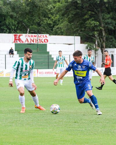 El volante auriazul, Gastón Pinedo transporta el esférico ante la cercana presencia del acatante ñuense, Edsson Riveros. (Foto: APF)