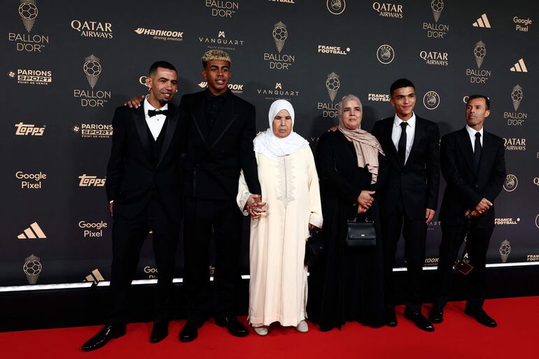 Lamine Yamal tomado de la mano de su abuela Fátima y rodeado de otros familiares en el Theatre du Chatelet en París. (FRANCK FIFE / AFP)
