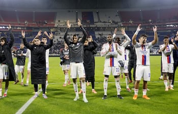 Jugadores de Lyon celebran el triunfo y el liderato en Europa.