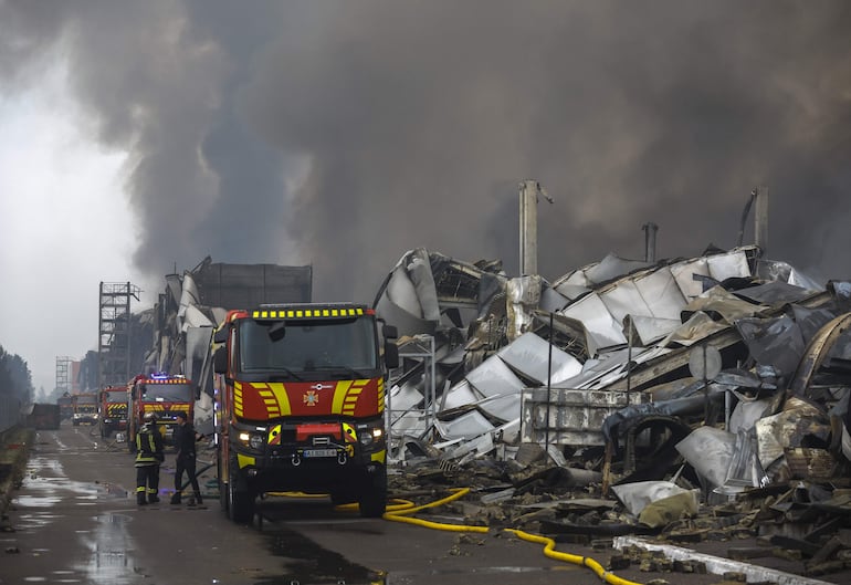 Bomberos trabajan en una zona afectada por el bombardeo ruso en Kiev.