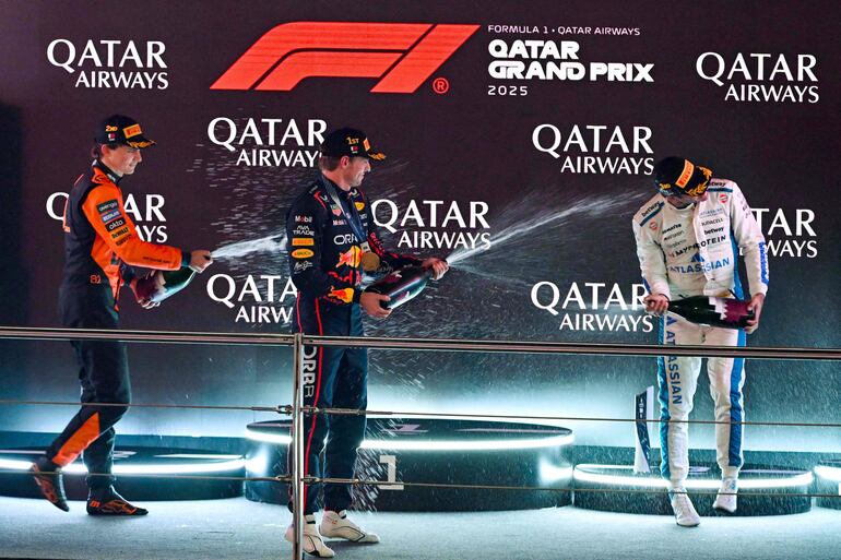 Festejo con champaña en el podio. Max Verstappen (centro), Oscar Piastri (izq.) y Carlos Sainz.