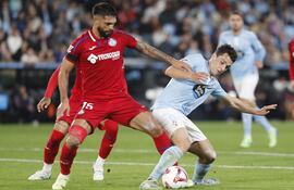 VIGO, 04/11/2024.- El delantero griego del Celta de Vigo Anastasios Douvikas (d) disputa un balón ante el defensa paraguayo del Getafe CF Omar Alderete, durante el encuentro correspondiente a la jornada 12 de Laliga EA Sports que disputan Celta de Vigo y Getafe CF hoy lunes en el estadio de Balaídos, en Vigo. EFE / Salvador Sas