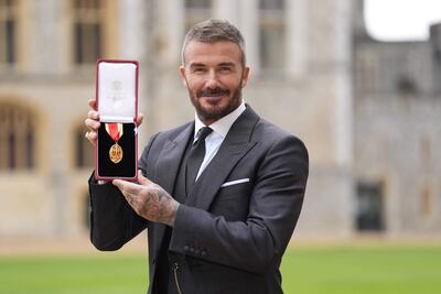 David Beckham muestra orgulloso su medalla tras ser nombrado Caballero en una ceremonia de investidura en el Castillo de Windsor.