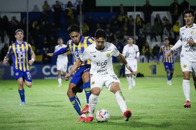 El mediocampista de Guaraní, Aldo Maíz protege el esférico ante la presión de volante del Sportivo Luqueño, Víctor Sebastián Quintana.