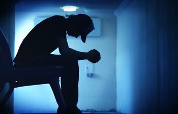 Silueta de hombre cabizbajo.