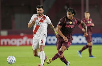 El delantero argentino Enrique Triverio de Always Ready y el defensa paraguayo José María Canale de Lanús luchan por el balón durante el partido de fútbol de la fase de grupos de la Copa Libertadores, en el estadio Ciudad de Lanús, en la provincia de Buenos Aires.