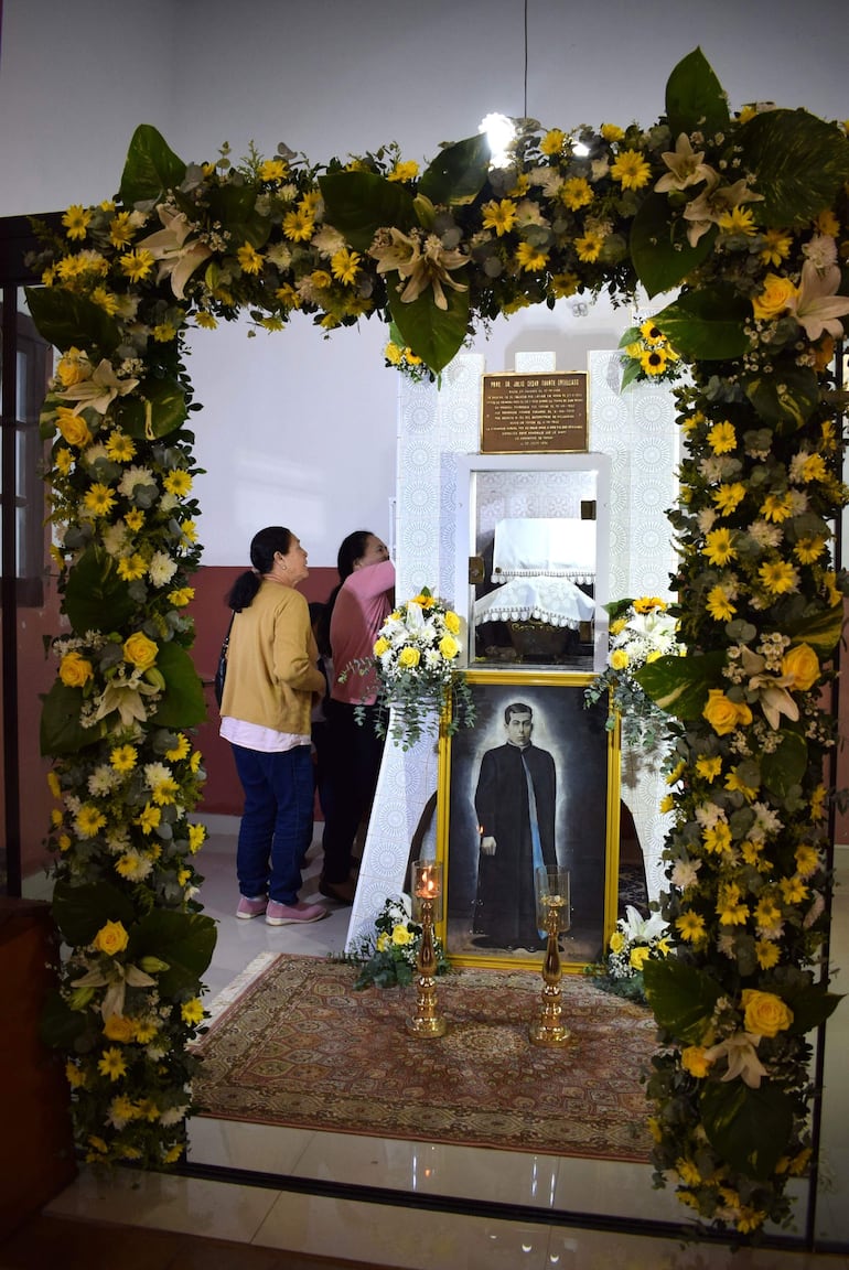Fieles católicos piden la intercesión del Padre Julio César Duarte Ortellado en un altar florido en Ybycuí.