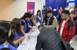 Trabajadores firman documentos este lunes, en el Aeropuerto Internacional Silvio Pettirossi en Luque (Paraguay). Un primer grupo de 45 trabajadores agrícolas de Paraguay partió a España como parte de un plan piloto previsto en un programa de Migración Circular suscrito por ambos países, que busca atender la alta demanda de mano de obra en la temporada de frutos rojos de Huelva, en la comunidad autónoma de Andalucía. EFE/ Ron González