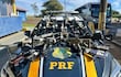 Vehículo patrullero de la Policía Federal con varias armas de fuego sobre su capó en un ambiente exterior.