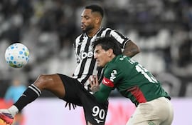 El delantero brasileño de Botafogo Danilo Pereira da Silva intenta aguantar de espaldas ante la marca del zaguero paraguayo de Palmeira, Gustavo Gómez.