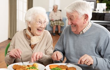 Pareja sénior disfruta de una cena sabrosa.
