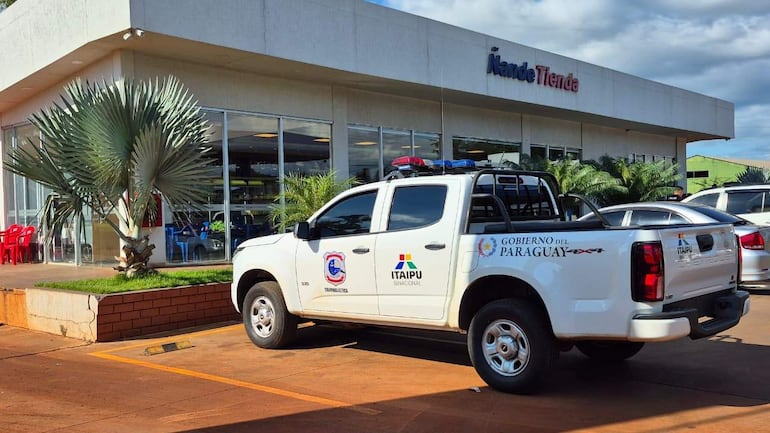 Estación de servicios con camioneta del Gobierno del Paraguay frente a un edificio moderno y palmera.