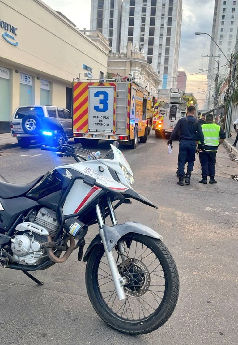 Agentes policiales y de la PMT asisten a bomberos en el incendio que se registra en un depósito en la calle Tacuary y Eligio Ayala.