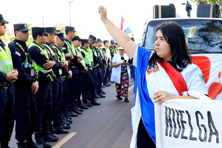 Una mujer participa en una manifestación de médicos en la que exigen un reajuste de salarios, dotación en los hospitales y mejores condiciones laborales este viernes, en Cambyretá (Paraguay).