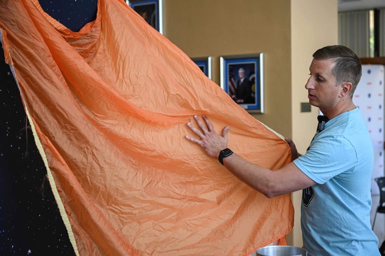 Jared Daum, ingeniero aeroespacial del NASA Johnson Space Center, exhibe el sistema de paracaídas de la nave Orion el 9 de abril de 2026 en el Centro Espacial Johnson, en Houston, Texas.