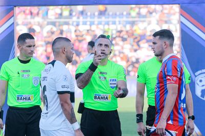 Richard Ortiz (i), jugador de Olimpia, y Fabrizio peralta, futbolista de Cerro Porteño, en el sorteo que realiza el árbitro Carlos Paul Benítez en la previa del superclásico del torneo Apertura 2024 del fútbol paraguayo en el estadio Defensores del Chaco, en Asunción.
