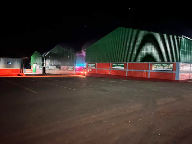 El depósito de yerba canchada iluminado por las llamas, sin personas visibles, creando un ambiente desolador.