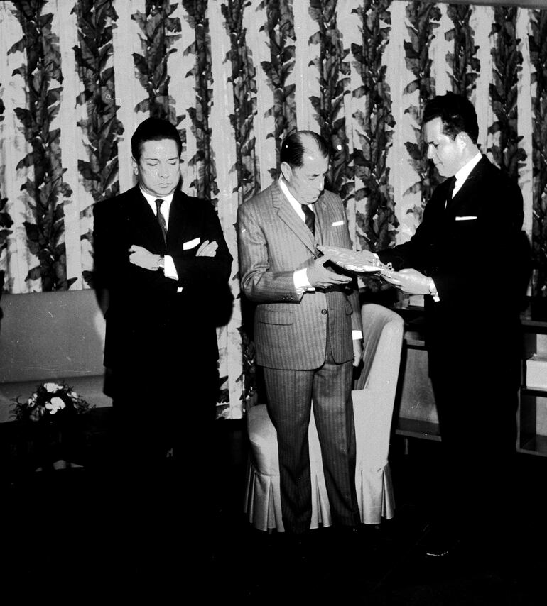 El entonces diputado Atilio R. Fernández y Numa Alcides Mallorquín entregan el pabellón al representante ecuatoriano.