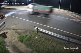 Un camión en movimiento parece ignorar una rampa lateral en una carretera oscurecida por la noche.