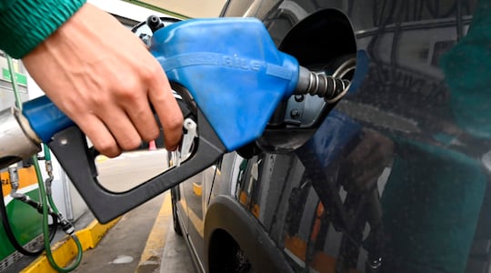 Una mano inserta la bomba de combustible en un vehículo en una estación de servicio en Asunción.