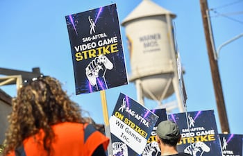 Actores de doblaje en videojuegos, artistas de captura de movimiento y otros protestan el jueves fuera de la sede de Warner Bros. Games en Burbank, California.