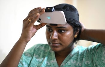 Esta fotografía, tomada el 15 de mayo de 2026, muestra a la ama de casa india Nagireddy Sriramyachandra usando un teléfono inteligente sujeto a la cabeza mientras registra sus acciones mediante captura de movimiento en su casa de Chennai.