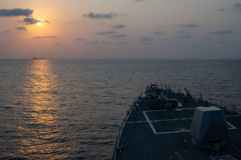 El destructor de misiles guiados USS Pinckney (DDG 91) observa un buque mercante mientras patrulla aplicando el bloqueo de Estados Unidos contra Irán.