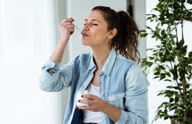 Mujer comiendo un yogur.