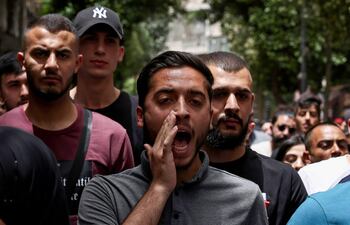 La gente corea consignas durante una manifestación en Ramallah, en la ocupada Cisjordania, el 27 de mayo de 2024, para protestar por un ataque israelí nocturno contra un campamento para palestinos desplazados internos en Rafah, en la Franja de Gaza.