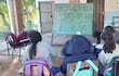 Estudiantes de la escuela Nueva Asunción de Chacó'i dan clases bajo un árbol y comparten la pizarra entre varos grados.
