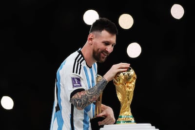 El argentino Lionel Messi toca el trofeo de la Copa del Mundo al pasar junto a él tras ganar el premio al Balón de Oro durante la ceremonia de entrega de premios de la final de la Copa Mundial de la FIFA 2022 entre Argentina y Francia en el estadio de Lusail, en Lusail, Qatar.