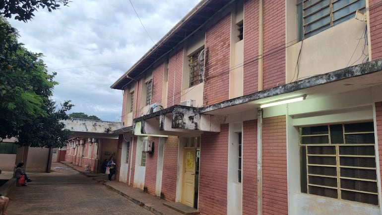 Edificio antiguo con ladrillos rosados y detalles blancos, sin personas visibles, en un entorno urbano.