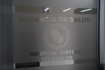Puerta de vidrio de oficina con inscripciones del IPS, 'Hospital Virtual Telesalud' y logo del Instituto de Previsión Social.