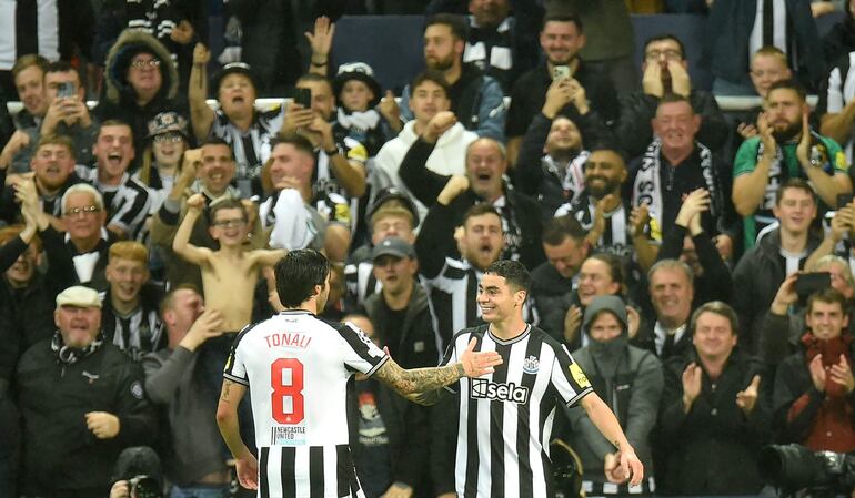 El paraguayo Miguel Almiron (d) y el italiano Sandro Tonali, jugadores del Newcastle, celebran un gol en el partido contra el PSG por la Liga de Campeones.