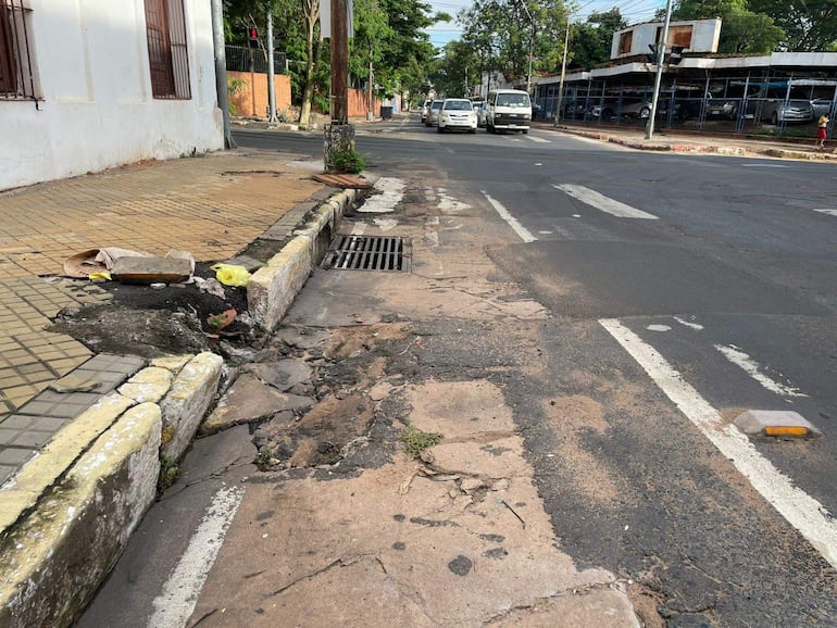 Escena urbana de la Bicisenda sobre Mariscal López, con calzada agrietada y vehículos circulando.