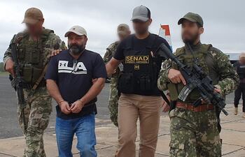 Levi Adriani Felicio, esposado, momentos antes de abordar el avión que lo trasladaría a su último destino antes de ser expulsado a su país.