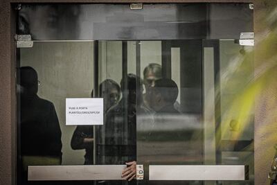 Fotografía que muestra al expresidente de Brasil Jair Bolsonaro (2-d) detrás de una puerta de vidrio, en la Superintendencia de la Policía Federal en Brasilia (Brasil). 