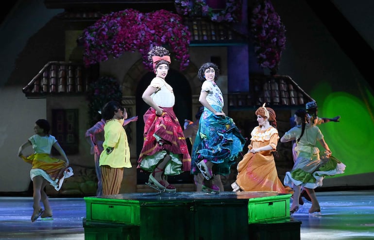 Bailarinas en trajes coloridos realizan movimientos dinámicos en un escenario festivo durante Disney on Ice.