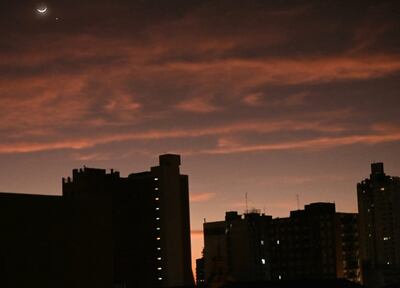 Vista de la luna en cuarto menguante en el cielo de Asunción, al amanecer.
